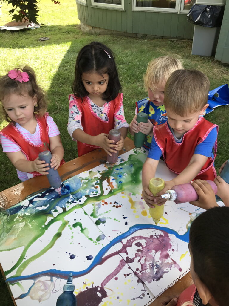 How to Teach Art to Different Ages, four children squeezing paint on table, watercikir