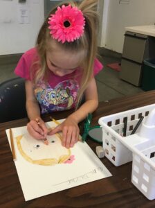 Teaching children drawing lessons, girl drawing self portrait.